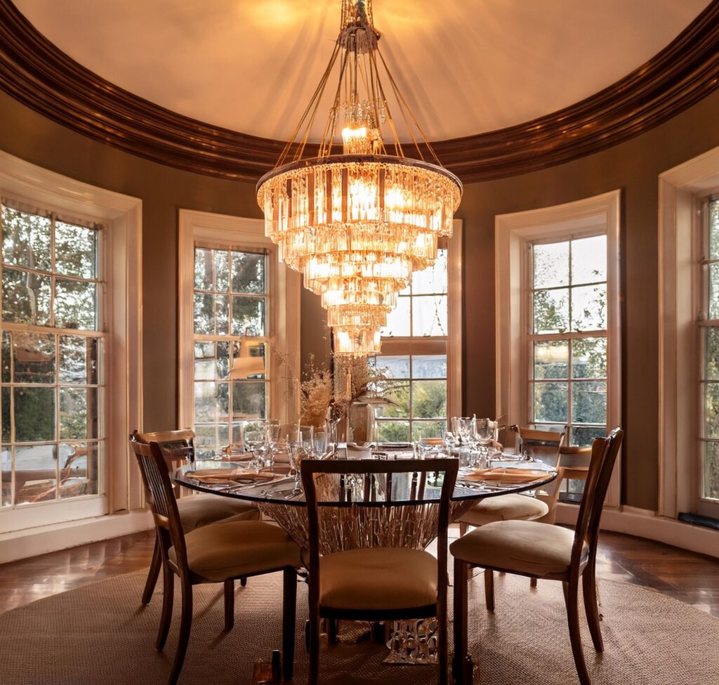 Vintage glass chandelier with soft lighting, casting a warm glow in a cozy dining room